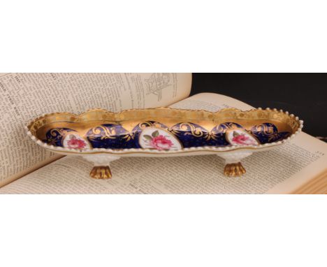 An English porcelain shaped oval pen tray, the field with three oval reserves painted with pink roses, on a cobalt blue groun