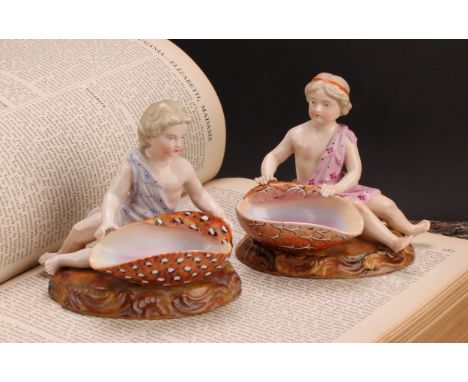 A pair of 19th century Sitzendorf figural table salts, of children holding seashells, decorated in polychrome, 11cm high, pai