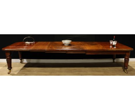 A William IV mahogany extending dining table, rounded rectangular top, four additional leaves, turned legs carved with lotus,