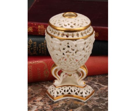 A Graingers Worcester reticulated ovoid pedestal vase and cover, moulded with classical masks, three scroll legs on tri-form 