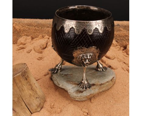 A George III silver mounted coconut cup, the fittings engraved with leafy stems, on a hatched ground, cabriole legs with lion