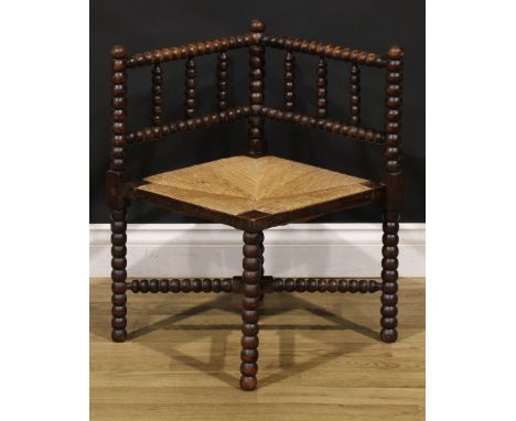 An Arts &amp; Crafts beech bobbin-turned corner chair, of small proportions, rush seat, 60.5cm high, 40cm square, c.1920 