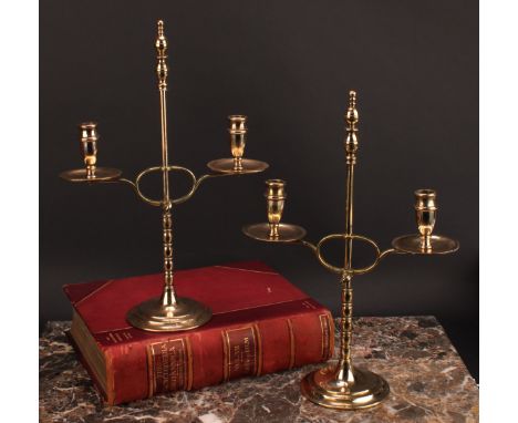 A pair of early 20th century brass two-light adjustable candelabra, orb-and-knop finiasls, broad drip pans, circular bases, 3