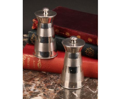 A pair of Art Deco style silver spreading cylindrical pepper mills of grinders, each engine turned with two broad bands, 9.5c