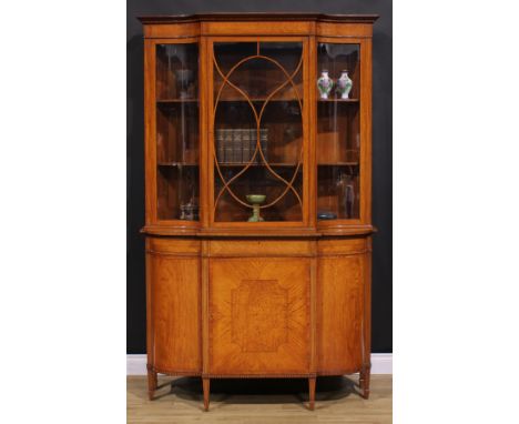 An Edwardian Sheraton Revival tulipwood and rosewood crossbanded satinwood break-centre display cabinet, outswept cornice wit