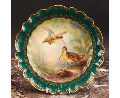 A George Jones &amp; Sons shaped circular plate, painted by W. Birbeck, with Woodcock, within gilded green border, 22cm diame