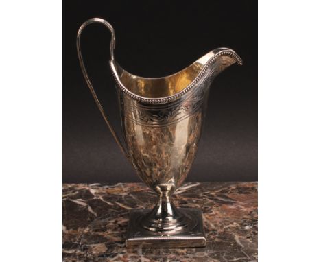 A George III silver helmet shaped cream jug, bright-cut engraved and outlined with wrigglework, beaded rim, scroll handle, sq