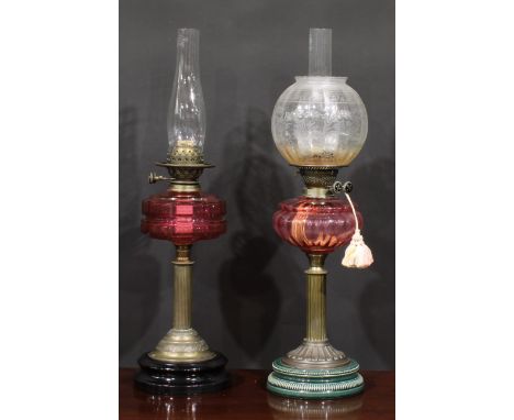 A late Victorian/Edwardian oil lamp, Duplex burner, facetted cranberry glass font, brass column support, black glazed stepped