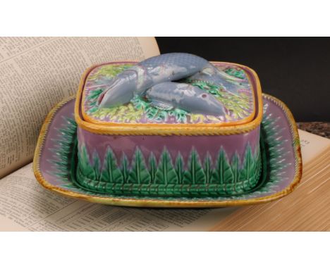 A George Jones majolica rounded rectangular sardine box and stand, the cover surmounted by fish, glazed in mottled tones of p