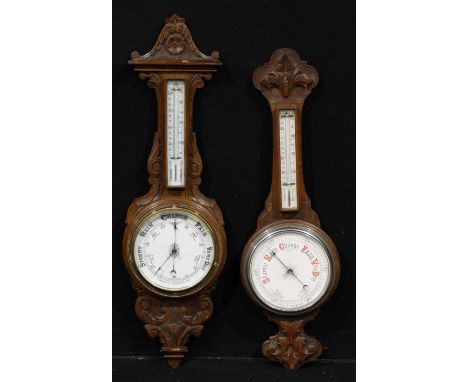 A late Victorian/ Edwardian oak wheel barometer, 19cm register, mercury thermometer, the case carved with acanthus scrolls, 9