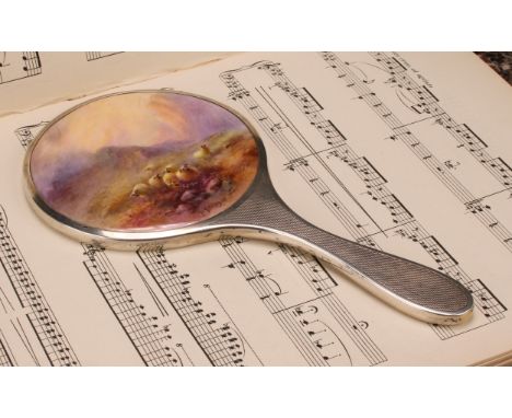 A Royal Worcester mounted silver hand mirror, the plaque painted by Harry Stinton, signed, with sheep in a Highland landscape