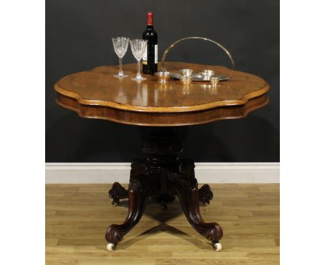 A Victorian rosewood centre table, serpentine oval tilting top, turned column carved with flower heads, cabriole legs, scroll