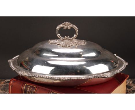 A George III silver oval vegetable dish, ogee cover with leafy loop handle, enclosing a detachable liner, gadrooned shell and