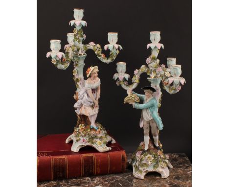 A pair of Sitzendorf figural four-light candelabra, modelled as a courting couple, each painted in polychrome and encrusted w