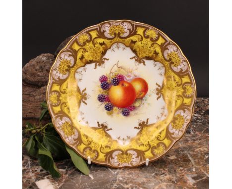 A Royal Worcester shaped circular plate, painted by J. Freeman, signed, with ripening fruit within fancy gilt cartouche, the 