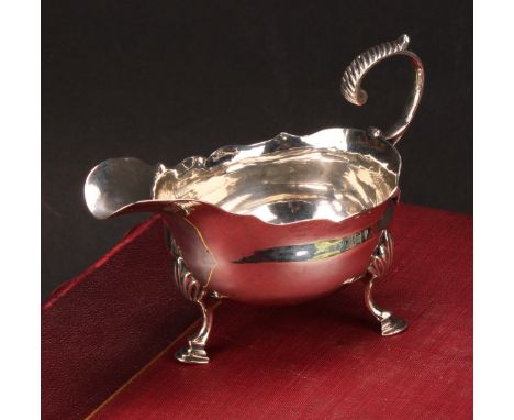 A George III silver sauce boat, acanthus-capped flying scroll handle, wavy rim, hoof feet, 13cm long, Thomas Shepherd, London