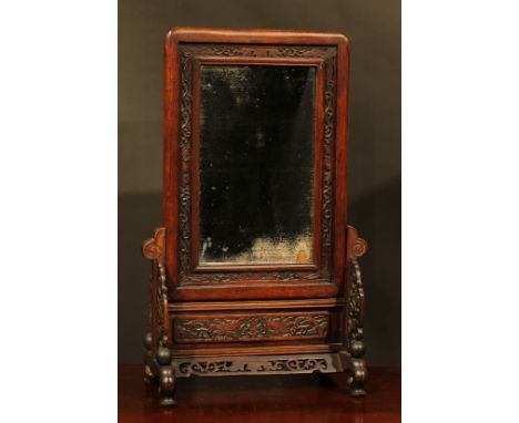 A Chinese hardwood table screen, rounded rectangular banner with mirror plate, pierced and carved with leafy scrolls, 74cm hi