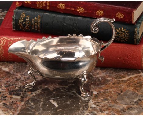 A George II silver sauce boat, acanthus-capped flying scroll handle, wavy border, hoof feet, crested, 13cm long, Benjamin Wes