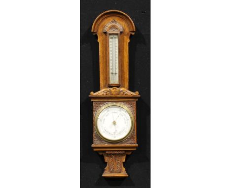 A late Victorian/Edwardian oak barometer, of smaller proportions, 10.5cm circular register, the domed case carved with acanth