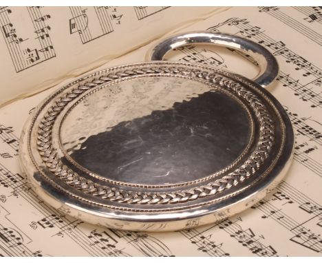 Amy Sandheim (1875 - 1958) - an Arts and Crafts silver circular hand mirror, Celtic knotted border, arched handle, planished 