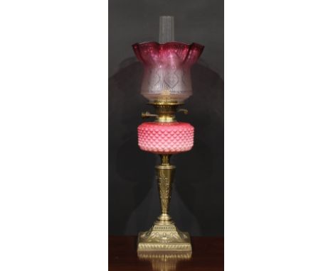 A Victorian brass and pink Vaseline glass table oil lamp, etched cranberry flashed shade, the base chased in the neoclassical