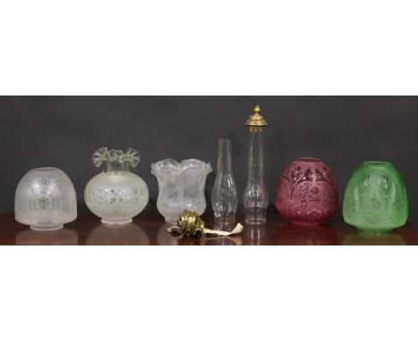 A 19th century ovoid cranberry glass oil lamp shade, frosted and moulded with flowers and foliage, 19.5cm high; another simil