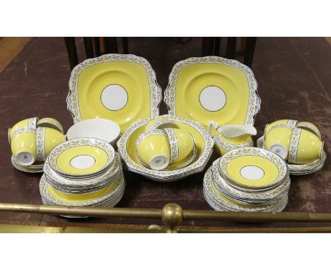 A Paragon china tea service yellow ground and decorated with trailing bands of ribbons and leaves, approximately fifty pieces