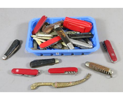 A box of assorted folding pocket knives including multi tool and Swiss examples.
