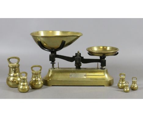 A pair of brass kitchen scales with graduated weights.