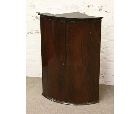 A Georgian mahogany bow front corner cupboard.