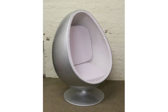 A Retro Style Swivel Egg Pod Chair With White Upholstery And