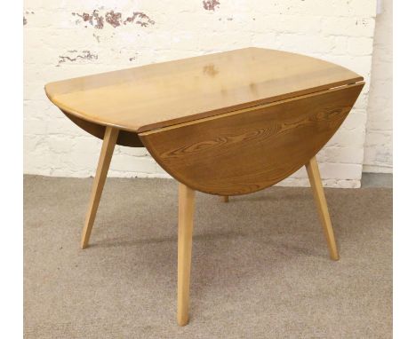 An Ercol Golden Dawn drop leaf dining table raised on tapering splayed legs.