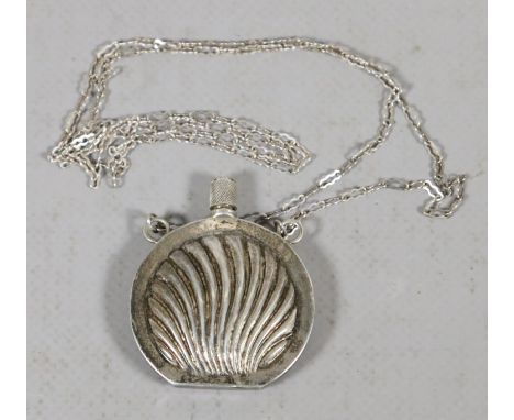 A silver scent flask on necklace chased with a shell motif.