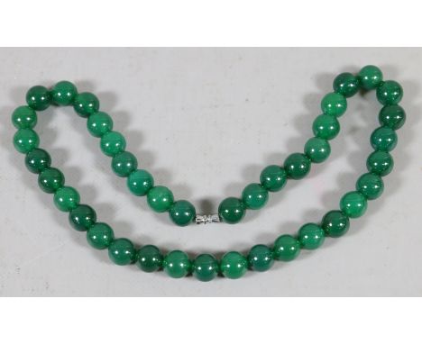 A string of spherical spinach jade beads with white metal threaded clasp.