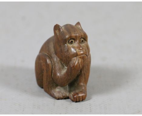 A Japanese early C20th carved hardwood netsuke formed as a crouching monkey, signed.