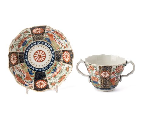 ‡ A WORCESTER CHOCOLATE CUP AND STAND, CIRCA 1770, painted in Japanese Kakiemon style with the 'Rich Queen's' pattern with pa