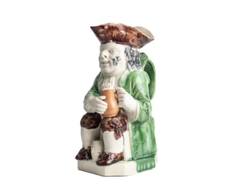 A STAFFORDSHIRE WOOD TYPE POTTERY TOBY JUG, CIRCA 1785, seated holding a jug of foaming ale, a barrel between his feet and a 