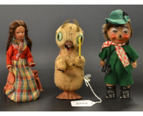 A Japanese clockwork bird, as a conductors holding a baton and song sheet, 16cm high, c.1950;   another as young girl with pl