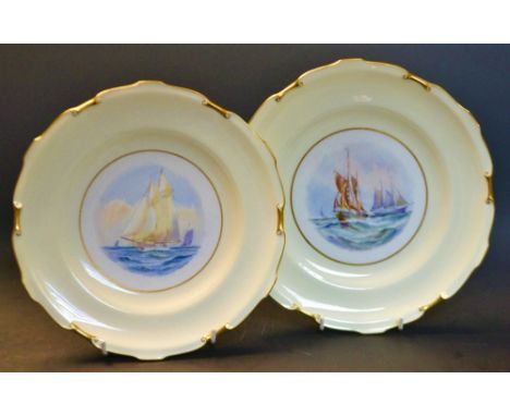 A pair of Royal Crown Derby shaped circular plates, painted  by W.E.J Dean, signed, painted with ships, within a pale yellow 