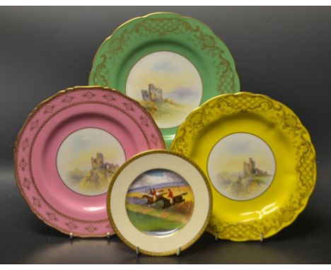 A set of three Royal Worcester shaped circular plates, painted with castle ruins, bordered in green, pink and yellow, printed