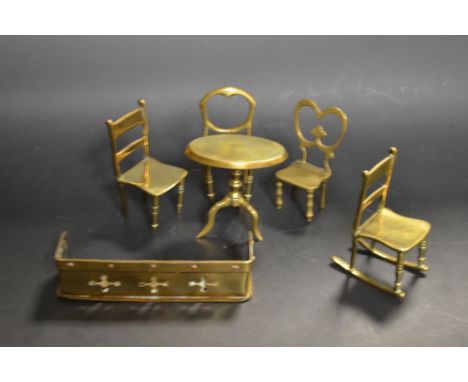 Victorian miniature brass furniture consisting of a tilt top tripod table, a fender and four chairs