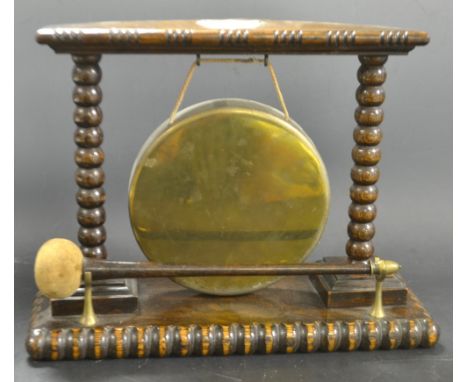A Victorian dinner gong with oak frame, bobbin turned uprights