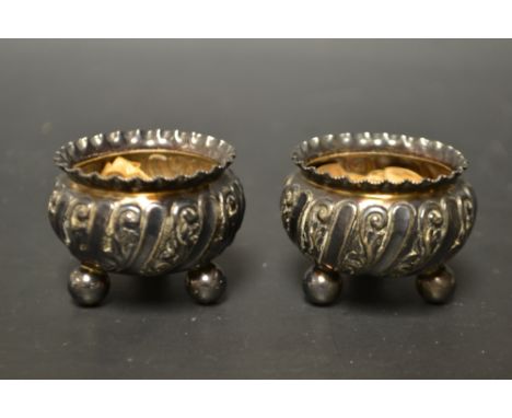 A pair of Edwardian silver table salts, cast body's, tripod ball feet, Walker & Hall, Sheffield 1901