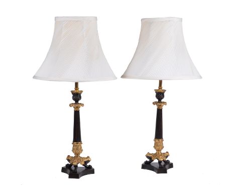 A pair of French gilt and lacquered metal candlesticks in Louis Philippe taste refitted as table lamps, the electrical fitmen