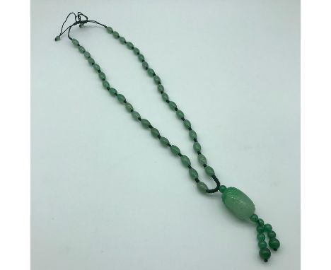 A jade necklace with carved pendant. 