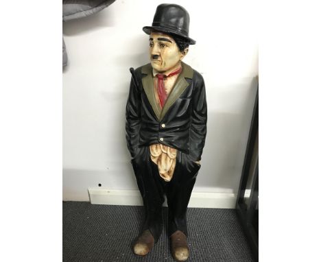 A Rare large Charlie Chaplin figure, Holding a stick under his arm. Made from a resin material. Stands 96cm in height. 