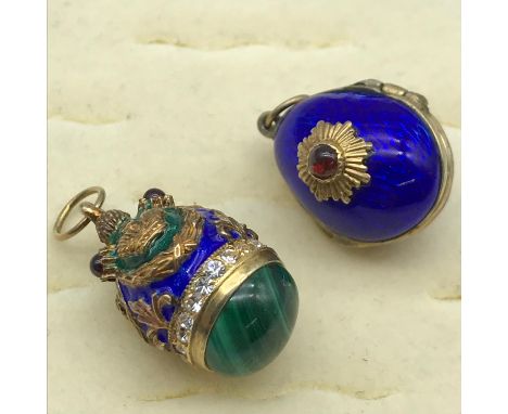 A Lot of two various faberge egg style pendants. One is styled with enamel, gilt crowns and a malachite stone to the base. Th