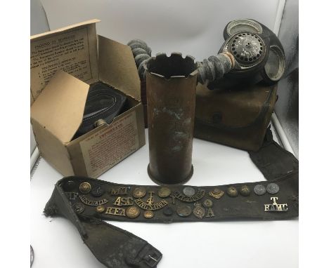 A Lot of WW2 Collectables includes 3 Gas masks, Military belt covered in badges and titles &amp; WW1 trench art shell vase. 