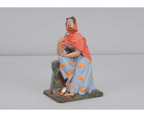 A mid 19th century Thüringen smoking gypsy woman nodder, the seated papier-mâché figure looking to the side with brown eyes, 