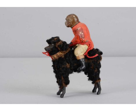 A late 19th century German composition monkey riding a poodle candy container,  the monkey in moulded red and white uniform h